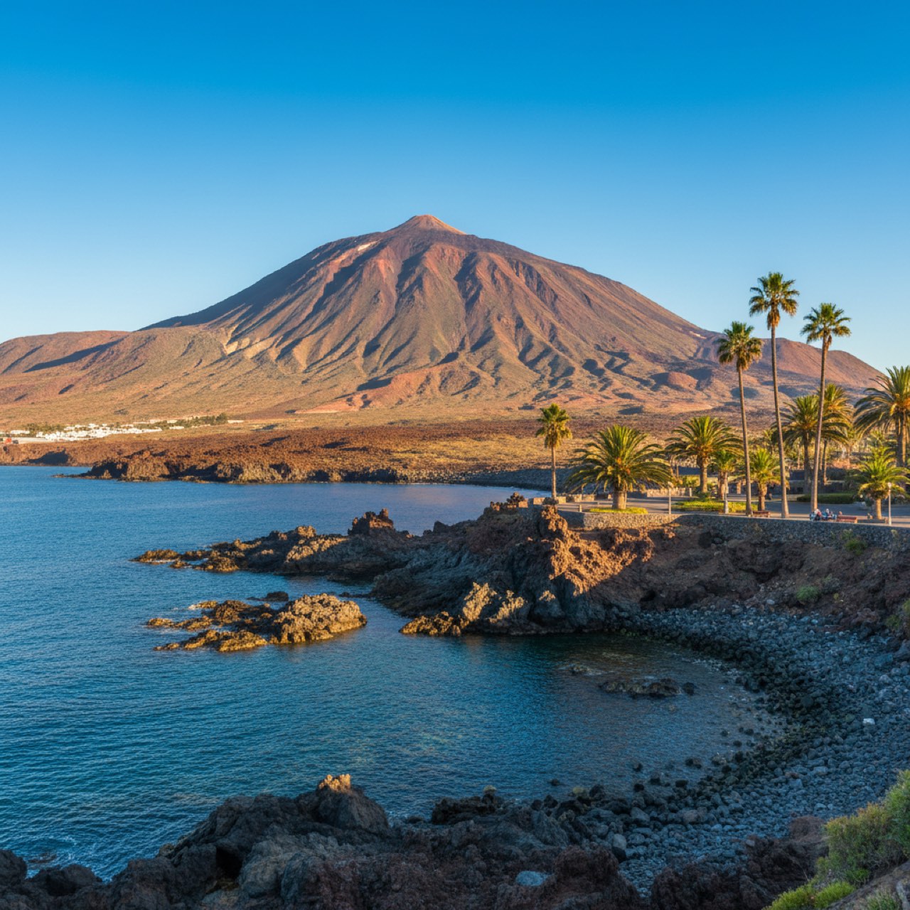 Landschaft auf Teneriffa mit dem Vulkan Teide im Hintergrund und der Atlantikküste mit Palmen im Vordergrund