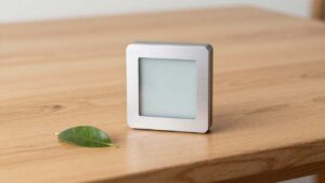 Ein moderner smarter Thermostat aus Aluminium auf Holz – Einstieg in die Smart Home Technik.